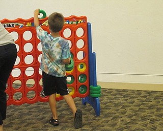 Neighbors | Alexis Bartolomucci.Families played a game of "Connect Four" with each other as part of the Family Game Night on July 10 at the Austintown library.