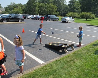 Neighbors | Alexis Bartolomucci.Children played cornhole outside in the Boardman library parking lot as they waited their turn for the pony rides.