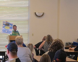 Neighbors | Alexis Bartolomucci.Michael Albert showed the guests at the Austintown library Pop Art program one of his posters he created.