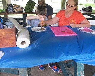 Neighbors | Alexis Bartolomucci.One of the children at Camp FRIEND painted brown spots on his canvas as he prepared to make flowers out of his handprints.