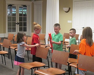 Neighbors | Alexis Bartolomucci.Children read clues they found hidden around different places at the Poland library during their Spanish Class scavenger hunt on July 3.