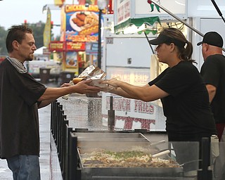 Jason Lowry of Hubbard purchases a large Italian sausage sandwich from Diana Mollen of Shirley's during the Greater Youngstown Italian Festival, Friday, August 4, 2017 in Downtown Youngstown...(Nikos Frazier | The Vindicator)