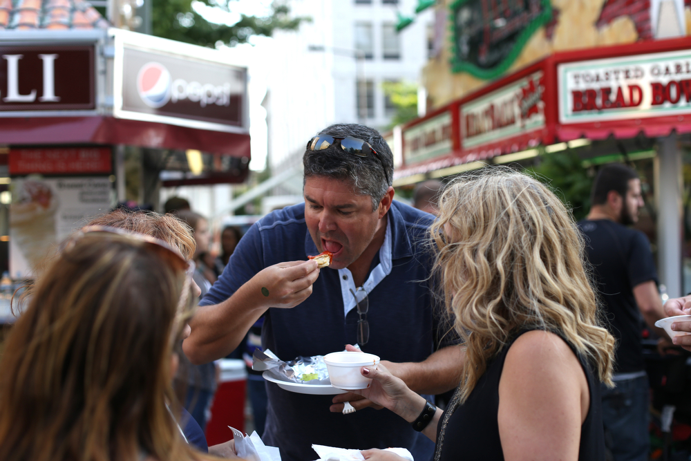 Adam Burke of Sandy Springs, Ga. enjoys a strombolli from LaRocca during the Greater Youngstown Italian Festival, Saturday, August 5, 2017 in Downtown Youngstown...(Nikos Frazier | The Vindicator)