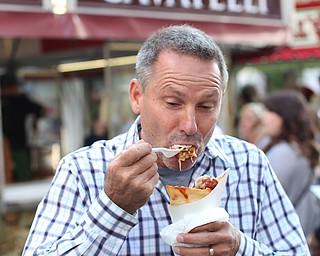 Dino Costello of Canfield enjoys a meatball bread cone from LaRocca during the Greater Youngstown Italian Festival, Saturday, August 5, 2017 in Downtown Youngstown...(Nikos Frazier | The Vindicator)