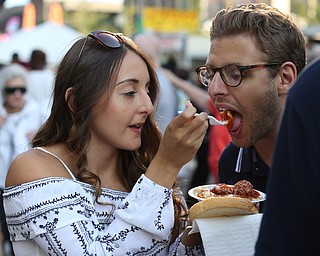 Matthew Melito takes a bite of girlfriend Sarina Mauerman's cavatelli dinner during the Greater Youngstown Italian Festival, Saturday, August 5, 2017 in Downtown Youngstown...(Nikos Frazier | The Vindicator)