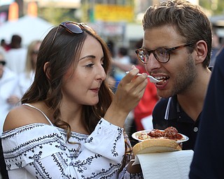 Matthew Melito takes a bite of girlfriend Sarina Mauerman's cavatelli dinner during the Greater Youngstown Italian Festival, Saturday, August 5, 2017 in Downtown Youngstown...(Nikos Frazier | The Vindicator)