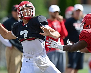 YOUNGSTOWN, OHIO - AUGUST 8, 2017: Youngstown State's Nathan Mays, black, throws a pass while under pressure from Malachi Newell, red, during the teams practice Tuesday morning at Stambaugh Stadium. DAVID DERMER | THE VINDICATOR