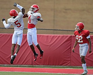 YOUNGSTOWN, OHIO - AUGUST 8, 2017: Youngstown State's Damoun Patterson and Alvin Bailey, white, celebrate after Patterson scored a touchdown on a long pass beating Darius Hall, red, during the teams practice Tuesday morning at Stambaugh Stadium. DAVID DERMER | THE VINDICATOR