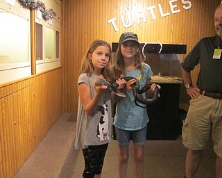 Neighbors | Alexis Bartolomucci.Jordyn and Frances held the black rat snake at Ford Nature Center as they celebrated its 20th birthday on July 15.
