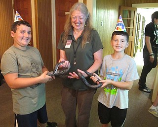 Neighbors | Alexis Bartolomucci.Jarrett and Casey Pitts held the black rat snake with the help of Marilyn Williams of Ford Nature Center as they celebrate the snake's 20th birthday on July 15.