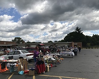 Neighbors | Alexis Bartolomucci.Cars lined up in the St. Christine parking lot for the Trunk and Treasure sale on Aug. 5 to sell different items.