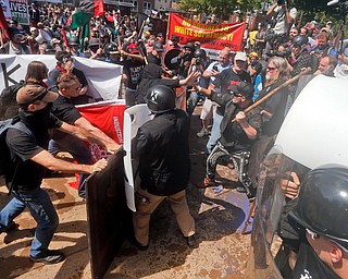 White nationalist demonstrators clash with counter demonstrators at the entrance to Lee Park in Charlottesville, Va., Saturday, Aug. 12, 2017. Gov. Terry McAuliffe declared a state of emergency and police dressed in riot gear ordered people to disperse after chaotic violent clashes between white nationalists and counter protestors. (AP Photo/Steve Helber)
