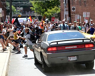 A vehicle drives into a group of protesters demonstrating against a white nationalist rally in Charlottesville, Va., Saturday, Aug. 12, 2017. The nationalists were holding the rally to protest plans by the city of Charlottesville to remove a statue of Confederate Gen. Robert E. Lee. There were several hundred protesters marching in a long line when the car drove into a group of them.   /The Daily Progress via AP)