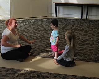 Neighbors | Zack Shively.Mallory Wiand and several children sat in the butterfly yoga pose on at the Austintown library's Build a Better You! event.