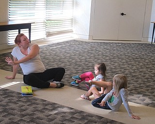 Neighbors | Zack Shively .Children tried out the dragonfly yoga pose at the Build a Better You! program.