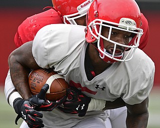 YOUNGSTOWN, OHIO - AUGUST 19, 2017: Youngstown State's Alvin Bailey, white, is hit by Lee Wright, red, after a reception during the teams practice Saturday morning at Stambaugh Stadium. DAVID DERMER | THE VINDICATOR