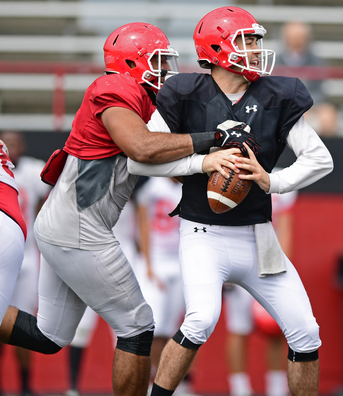 YOUNGSTOWN, OHIO - AUGUST 19, 2017: Youngstown State's Hunter Wells, black, is sacked by Justus Reed, red, during the teams practice Saturday morning at Stambaugh Stadium. DAVID DERMER | THE VINDICATOR