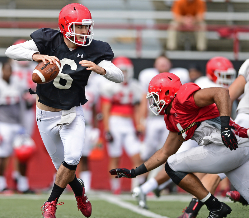 YOUNGSTOWN, OHIO - AUGUST 19, 2017: Youngstown State's Hunter Wells, black, rolls away from pressure from Justus Reed, red, during the teams practice Saturday morning at Stambaugh Stadium. DAVID DERMER | THE VINDICATOR