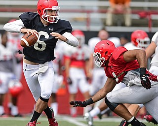 YOUNGSTOWN, OHIO - AUGUST 19, 2017: Youngstown State's Hunter Wells, black, rolls away from pressure from Justus Reed, red, during the teams practice Saturday morning at Stambaugh Stadium. DAVID DERMER | THE VINDICATOR