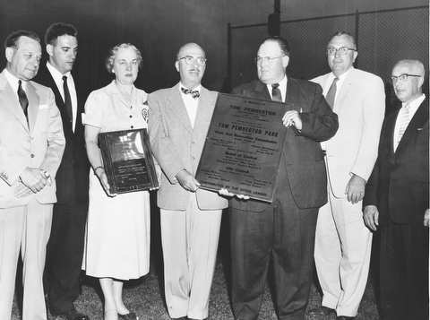 AUGUST 26, 1956 Vindicator Photo by Paul R. Schell  Mrs Tom Pemberton, widow of the former park superintendent, holds a special plaque presented to her while the new Tom Pemberton plate, to officially change the name of Shady Run Field is shown by Arnold Stambaigh at last night's dedication Left to right are Lester Donnell, master of ceremonies, Ed Finamore, park superintendent, Mrs. tom Pemberton, Frank Kline, park board director, Arnold Stambaugh who presented the plaque as a representative of the Stove Leaguers Leo Mason of the park board and Edgar Samuels who directed the Stove League plaque fund.