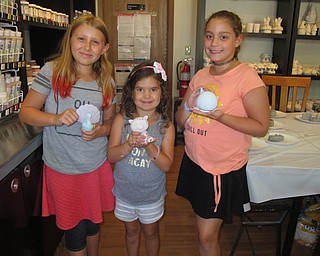 Neighbors | Alexis Bartolomucci.Katie, Eva and Olivia held up ceramic animals they painted during their week at Art Camp at Wonderstruck Market.