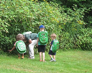 Neighbors | Zack Shively.Marilyn Williams and the children pretend to be turtles to think about a good place to hide during the Children's Nature Hour at the Ford Nature Center on Aug. 10.