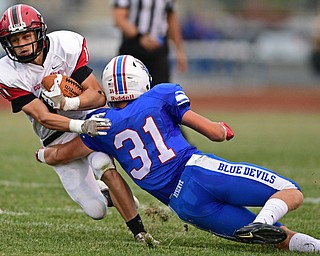 BERLIN CENTER, OHIO - AUGUST 24, 2017: Columbiana's Joe Bable is tackled by Western Reserve's Adam Gatrell during the first half of their game against Columbiana, Thursday night at Western Reserve High School. DAVID DERMER | THE VINDICATOR