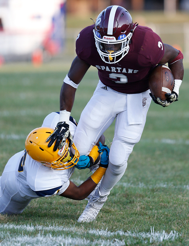 MICHAEL G TAYLOR | THE VINDICATOR-8-25-17 FOOTBALL Youngstown Golden Bears vs Boardman Spartans at Rayen Stadium, Youngstown, OH    1st qtr.,  Boardman's #3 Domonhic Jennings gains the 1st down as East''s #15 Marcus Finkley applies the hit.