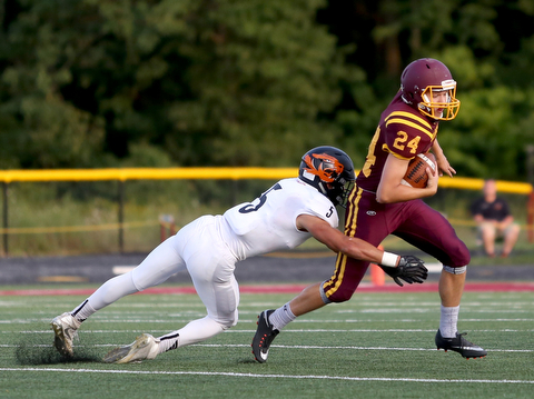 Springfield Local Tiger running back Ryan Ohlin  (5) tackles South Range Raiders kicker Brandon Youngs  (24) during the first quarter as Springfield local takes on South Range, Saturday, August 26, 2017, at Raider's stadium at the Rominger Sports Complex in Canfield...(Nikos Frazier | The Vindicator)..