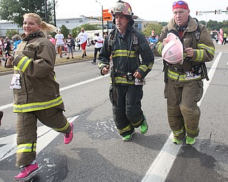 Stephanie McMasters of Wellsville, Kevin Orwick of Columbiana and William Slaypoole of West Point, Ga. run the 2 mile portion of the 8th annual Panerathon in their turnout gear, Sunday, August 27, 2017 at the Covelli Centre in Youngstown. The firefighters ran for Firefighters in Pink...(Nikos Frazier | The Vindicator)