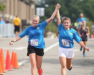 Paige Tabor(14) and Krista Borton(13) hold hands as they complete the 10k run during the 8th annual Panerathon, Sunday, August 27, 2017 at the Covelli Centre in Youngstown...(Nikos Frazier | The Vindicator)