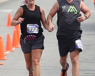 Pamela Lescsak and Patrick Abel hold hands as they complete the 10k run during the 8th annual Panerathon, Sunday, August 27, 2017 at the Covelli Centre in Youngstown...(Nikos Frazier | The Vindicator)