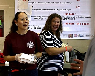 Anna Masi(left) of Youngstown and Sarah Ellis of Boardman smile as they sell the last two paczki during the 9th annual Polish American heritage festival, Sunday, August 27, 2017, at St. Anne's catholic Church in Austintown...(Nikos Frazier | The Vindicator)
