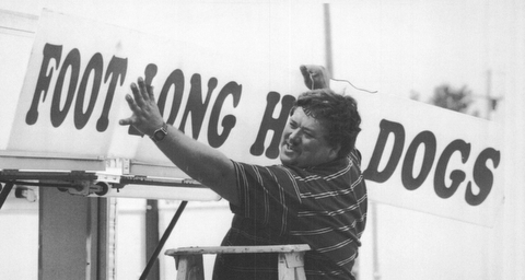 Leslie Hull a vendor at the 1992 Canfield Fair  who hails from Arizona hangs a sign at his hot dog stand.