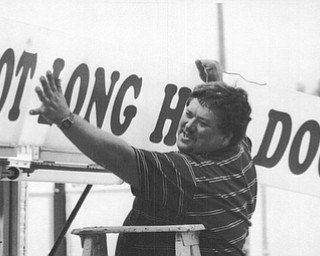 Leslie Hull a vendor at the 1992 Canfield Fair  who hails from Arizona hangs a sign at his hot dog stand.