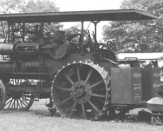 Glenn Fullerton of Burgettstown, Pa. shovels coal into his 1922 Farquhar steam tractor at the 1992 Canfield Fair.