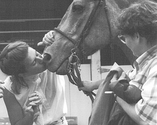 Trish Titus of Canfield gives her horse, Burritto a kiss after they took a spill in the Hunter Classic at the 1992 Canfield Fair. They fell because of thick mud in the ring.