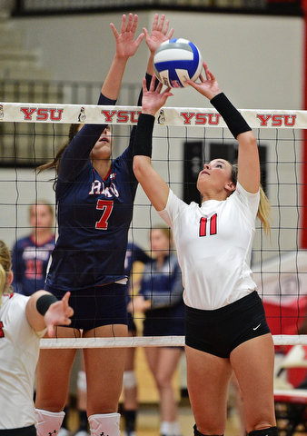 YOUNGSTWON, OHIO - AUGUST 29, 2017: Youngstown State's Heather Splinter sets the ball while Robert Morris's Maria Alfano goes for the block during their match Tuesday night at Beeghly Center. DAVID DERMER | THE VINDICATOR