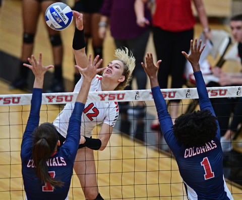 YOUNGSTWON, OHIO - AUGUST 29, 2017: Youngstown State's Margaux Thompson, center, hits the ball over Robert Morris's Maria Alfano and Deja Tamlin during their match Tuesday night at Beeghly Center. DAVID DERMER | THE VINDICATOR