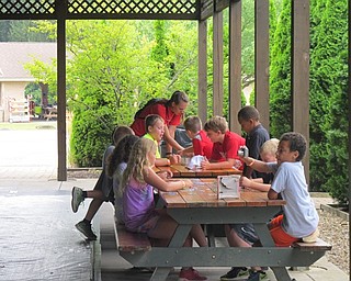 Neighbors | Zack Shively.A group at Boardman Park Camp's teamwork station works on solving a puzzle on Aug. 7.