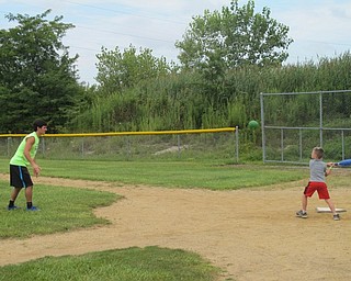 Neighbors | Zack Shively.A Boardman Park Camp counselor lobbed a pitch to swinging camper on Aug. 7.
