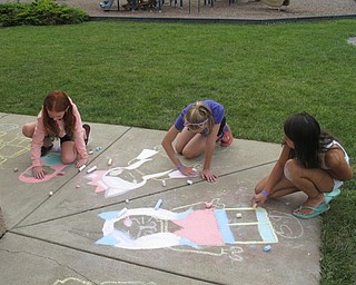 Neighbors | Zack Shively.Pictured, from left, are Kelsey, Dharma, and Anna drawing with sidewalk chalk at Boardman Park Camp on Aug. 7.