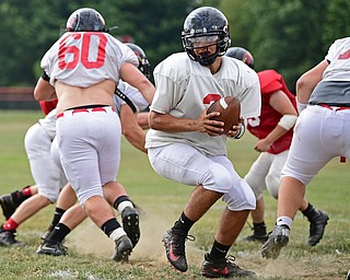 CANFIELD, OHIO - AUGUST 30, 2017: Canfield's Vinny Fiorenza drops back after receiving the snap from center Joe Haniford during the teams practice, Wednesday afternoon at Canfield High School. DAVID DERMER | THE VINDICATOR