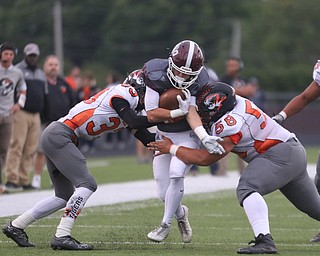             ROBERT  K. YOSAY | THE VINDICATOR..Boardmans #6 Joe Ieraci crashes through Howlands #33 Jonny Elliot and #58  Jack Lambert..First quarter action Howland Tigers at Boardman Stadium
