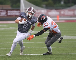             ROBERT  K. YOSAY | THE VINDICATOR..Boardman #6  joe Ieraci  Takes off for a big gain as Howland #33 reaches  for him Jonny Elliot....First quarter action Howland Tigers at Boardman Stadium