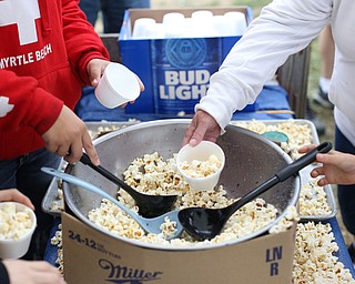 Kids scoop fresh popped popcorn into styrofoam cups at the 171st Canfield Fair, Saturday, Sept. 2, 2017, at the Canfield Fairgrounds in Canfield...(Nikos Frazier | The Vindicator)