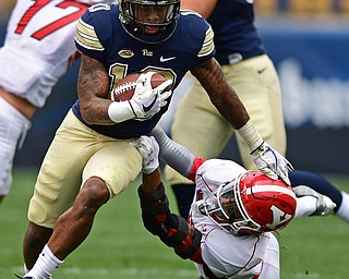 PITTSBURGH, PENNSYLVANIA - SEPTEMBER 2, 2017:  Pittsburgh's Quadree Henderson runs while Youngstown State's Jalyn Powell holds on during the first half of their game Saturday afternoon at Heinz Field. Pitt won 28-21 in overtime. (DAVID DERMER | THE VINDICATOR)