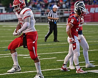 NILES, OHIO - SEPTEMBER 8, 2017: Struthers's Willie Mitchell, left, flexes after running over several Niles players and scoring a touchdown during the first half of their game Friday night at Niles High School. DAVID DERMER | THE VINDICATOR..Niles's Brandon Golias and Robbie Savin pictured.