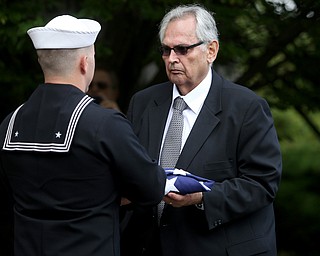 HM2 Todd Bollinger presents the flag that was draped over former state Sen. Harry Meshel's casket to a family member, Sept. 9, 2017, at Belmont Park Cemetery in Youngstown...(Nikos Frazier | The Vindicator)