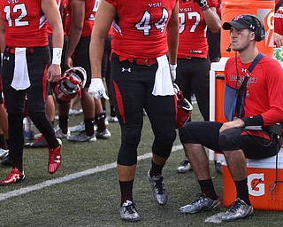 Youngstown State University quarterback Hunter Wells (6) sits on a cooler with his arm in a sling in the second quarter as Robert Morris University takes on Youngstown State University, Saturday, Sept. 9, 2017, at Stambaugh Stadium in Youngstown. Youngstown State won 30-0...(Nikos Frazier | The Vindicator)..